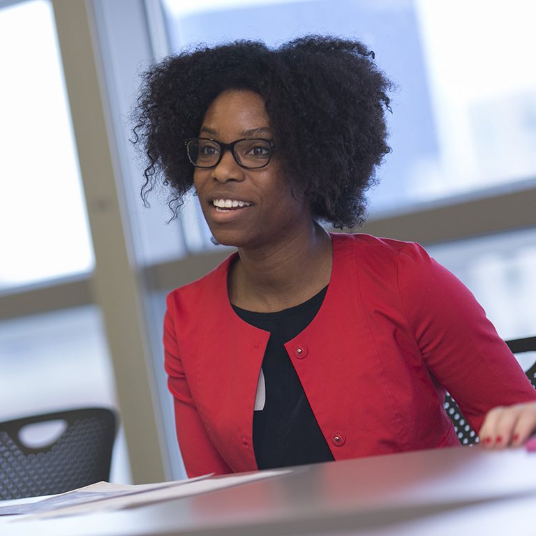 A SPEA student sits at a table and smiles at the teacher. 