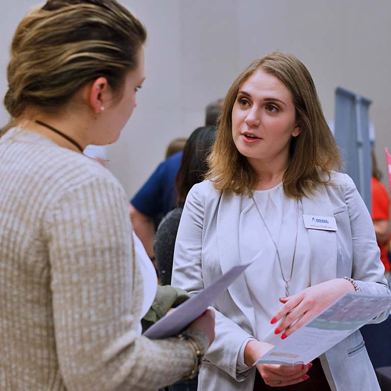 A nonprofit expo recruiter talks with a volunteer. 